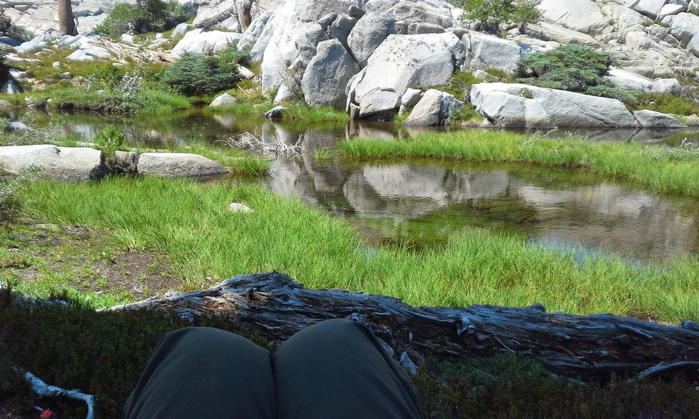 Resting alone on open granite above an alpine basin in Desolation Wilderness