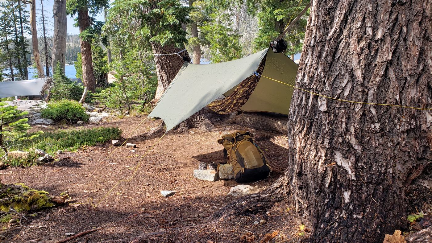 A worn rainfly pitched over a tent during a sudden afternoon thunderstorm in the Sierra