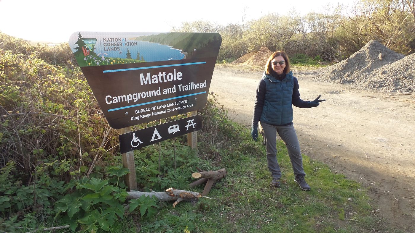 Backpacker at the Mattole Campground and Trailhead sign at the north end of the Lost Coast Trail