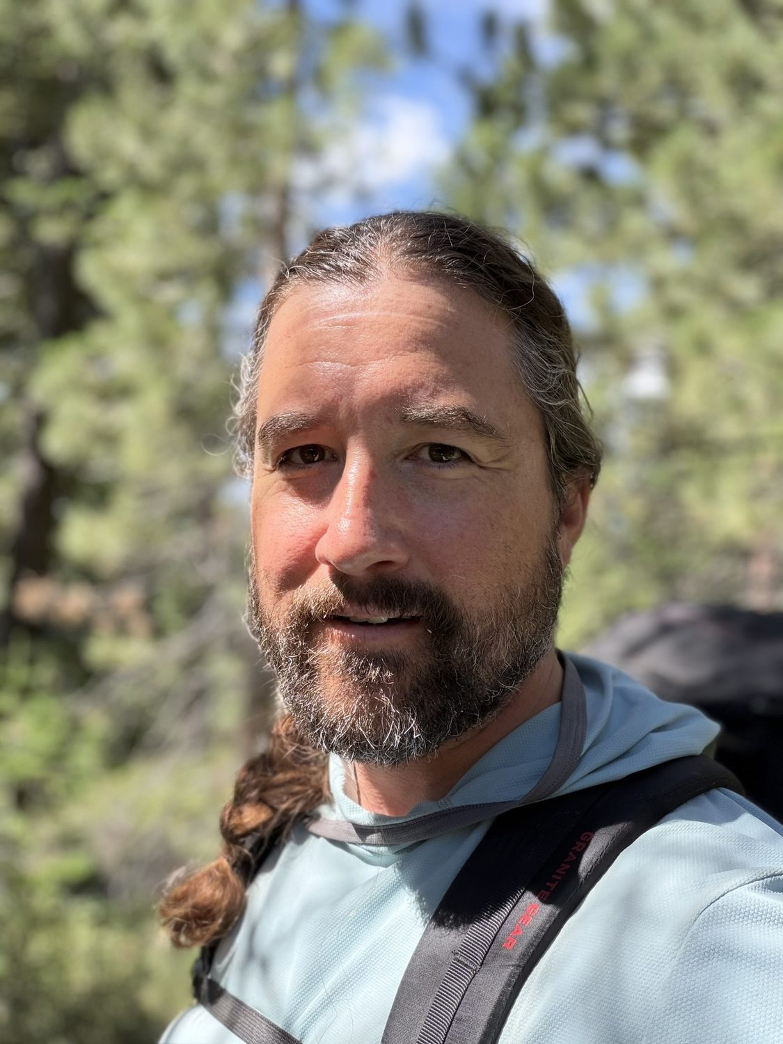 A close portrait of the hiker at the finish, sunburned and grinning, at the Brockway trailhead