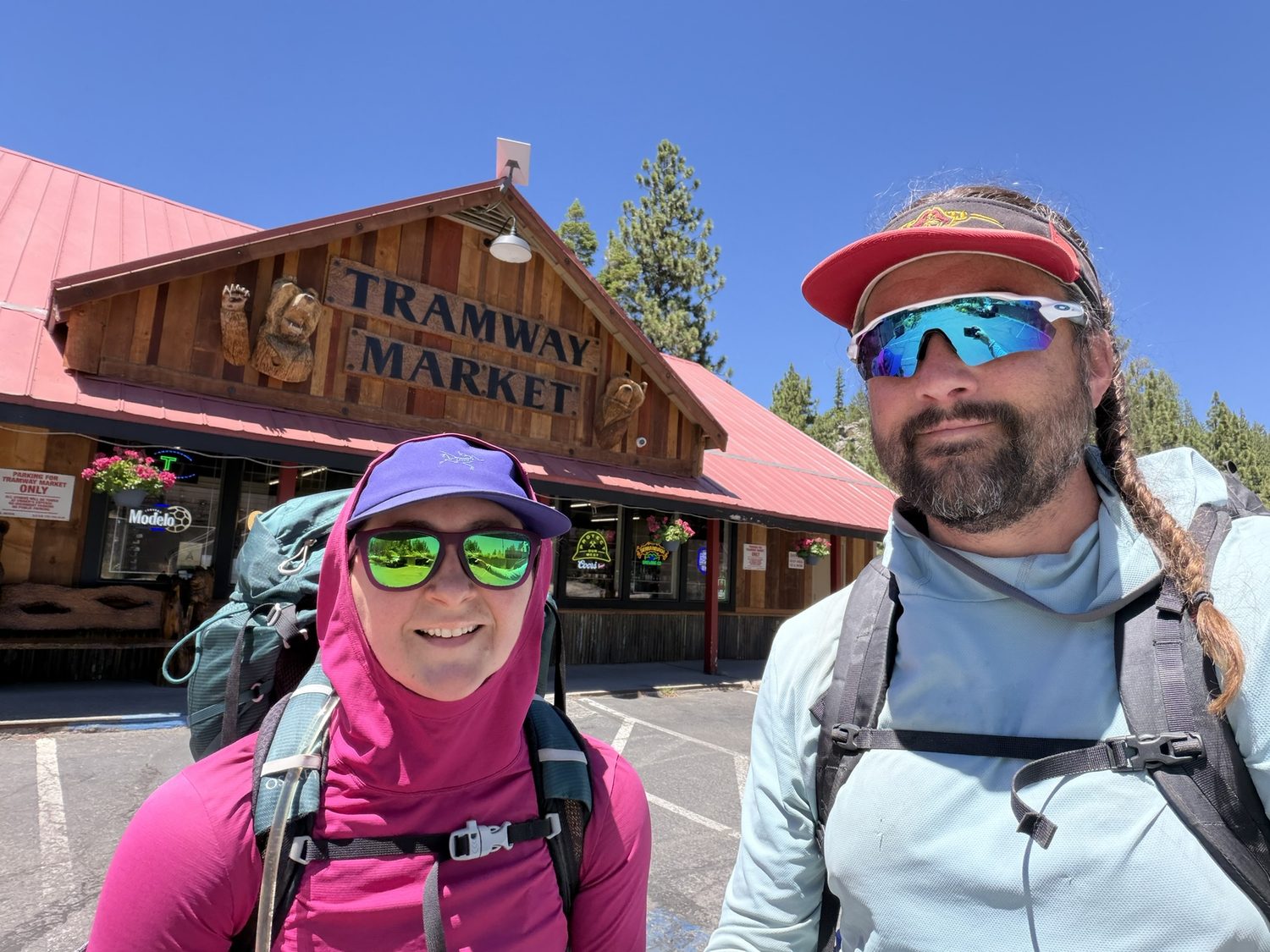 Two hikers taking a selfie outside the Tramway Market at Kingsbury with big grins