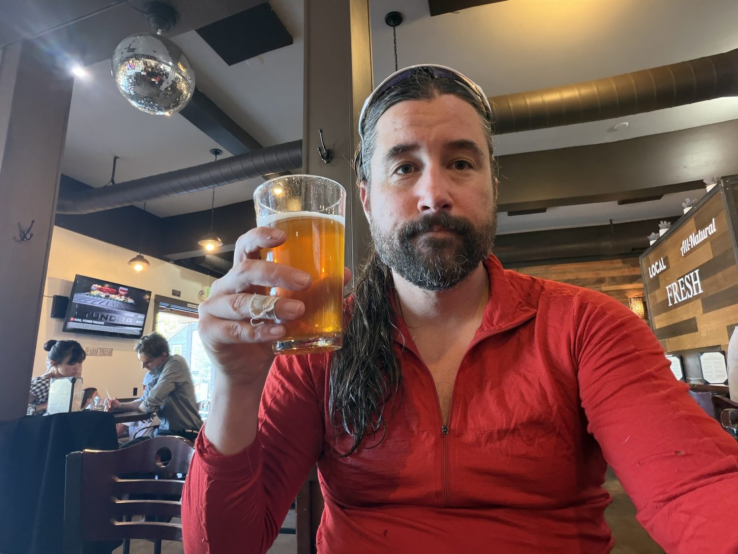 A hiker raising a glass of beer at a bar in Tahoe City at the end of the leg