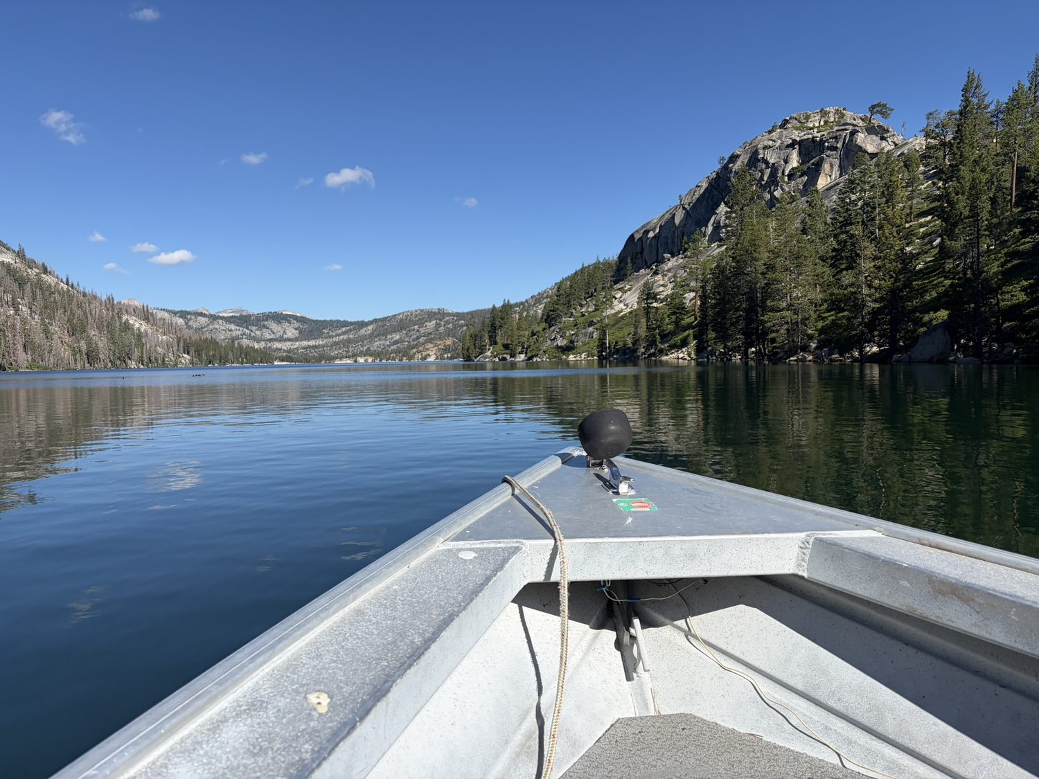 View from the bow of the Echo Lake water taxi crossing the blue lake toward granite peaks